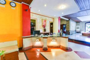 a lobby with a reception desk in a building at Super OYO Townhouse Oak Maxi Hotel Legian in Kuta
