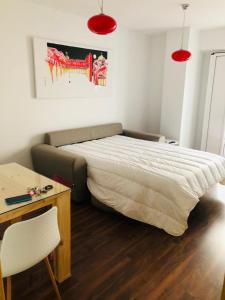 1 dormitorio con cama, mesa y luces rojas en Apartamento RENACIMIENTO con garaje, en Badajoz