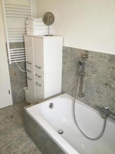 a bathroom with a bath tub with a shower at Ferienwohnung am Ziegelbach mit Balkon in Hechingen