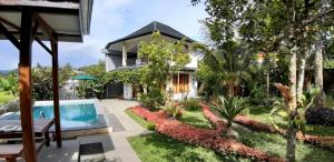una villa con piscina e una casa di The Aroma Villa Munduk a Mayong