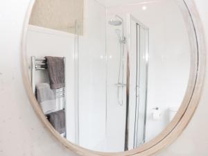 a mirror reflecting a shower in a bathroom at Gerrard House Apartment in Llandudno +23 photos
