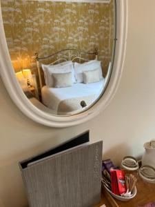 a bedroom with a bed with a mirror on the wall at Devonshire Arms Inn in Cracoe