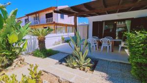 ein Haus mit einer Terrasse mit einem Tisch und Stühlen in der Unterkunft STAY Sea Gem House in Meneou