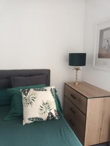 a bed with a pillow and a nightstand with a lamp at Superbe appartement et Parking proche du Centre du Monde in Perpignan