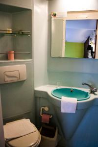 een badkamer met een wastafel, een toilet en een spiegel bij Logis Auberge de la Fontaine in Villiers-sur-Suize