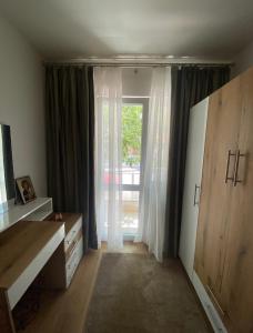a room with a large window with curtains and a dresser at Apartamentul GAVIOTA in Timişoara