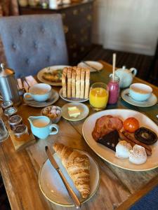 a wooden table topped with plates of breakfast foods at Devonshire Arms Inn in Cracoe