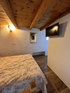 1 dormitorio con 1 cama y TV en la pared en Siesta Villas nearby Tzanaki Beach Livadi en Livadi Astypalaias