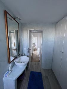 Baño blanco con lavabo y espejo en Siesta Villas nearby Tzanaki Beach Livadi en Livadi Astypalaias