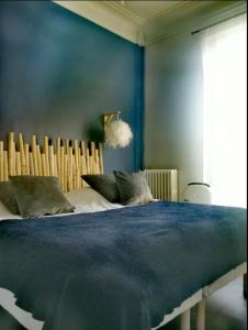 マルセイユにあるGrand Appartement haussmannienの青い壁のベッドルーム1室(大型ベッド1台付)