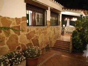 una casa con una pared de piedra y algunas plantas en Casa Marquesa, en Punta Umbría