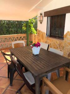 una mesa de madera con una maceta en el patio en Casa Marquesa, en Punta Umbría