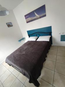 a bedroom with a large bed with a blue headboard at Résidence Les Hauts de France in Noeux-les-Mines