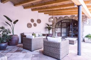 an outdoor patio with wicker chairs and a table at Hotel Monells Summum in Monells