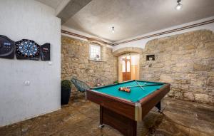 a pool table in a room with a stone wall at Holiday House Karla Valentina in Škropeti