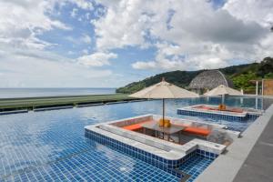a pool at a resort with a view of the ocean at Andamantra Resort and Villa Phuket - SHA Extra Plus in Patong Beach