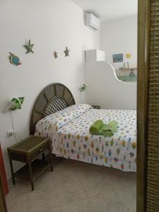 Schlafzimmer mit einem Bett und einem Tisch in der Unterkunft Il monolocale verde conchiglie e fiori in Ponza
