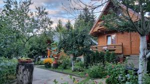 una casa de madera con un jardín delante de ella en Holiday Home SAJRA en Kulen Vakuf