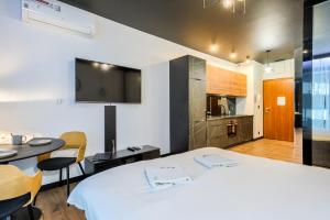 a room with a bed and a table and a kitchen at Wola Luxury Stay in Warsaw