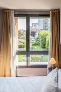 a bedroom with a bed and a large window at Art Hotel Olympic in Turin