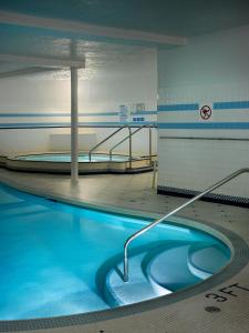 een zwembad met blauw water in een gebouw bij Royal Scot Hotel & Suites in Victoria