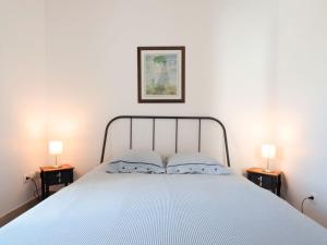 ein Schlafzimmer mit einem Bett mit zwei Lampen auf beiden Seiten in der Unterkunft Holiday Home De Malau - MPY400 by Interhome in Le Mesnil-Patry