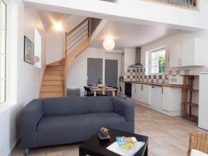 ein Wohnzimmer mit einem Sofa und einer Küche in der Unterkunft Holiday Home De Malau - MPY400 by Interhome in Le Mesnil-Patry