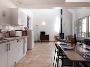 eine Küche und ein Wohnzimmer mit einem Tisch und Stühlen in der Unterkunft Holiday Home De Malau - MPY400 by Interhome in Le Mesnil-Patry