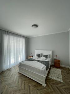 a white bedroom with a bed and a large window at Villa Le Grand Bleu in Đenovići