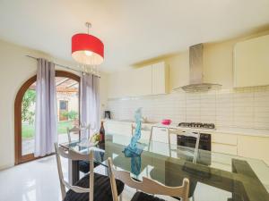cocina con mesa de cristal y algunas sillas en Holiday Home Villa Ulivo by Interhome, en Orentano