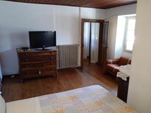 a bedroom with a television and a dresser with a bed at B&B SAN GIORGIO in Domodossola