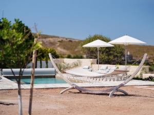 ein paar Hängematten neben einem Pool in der Unterkunft Patmosphere Luxury Escape Adults-Only in Patmos
