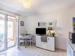 a kitchen and dining room with a table and a television at Apartment Les Roches Bleues-1 by Interhome in Collioure