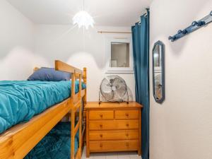 a bedroom with a bed and a dresser and a fan at Apartment Les Roches Bleues-1 by Interhome in Collioure