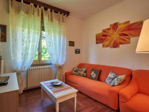 ein Wohnzimmer mit einem orangenen Sofa und einem Tisch in der Unterkunft Apartment Laghetto by Interhome in Carlazzo