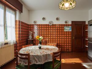 ein Esszimmer mit einem Tisch und einer Blumenvase darauf in der Unterkunft Apartment Laghetto by Interhome in Carlazzo