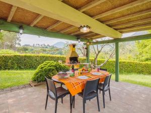 MontemagnoにあるHoliday Home Verde Versilia by Interhomeのパーゴラの下に座るテーブルと椅子