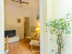 a living room with a flat screen tv and yellow chairs at Apartment Gracia Torrijos by Interhome in Barcelona