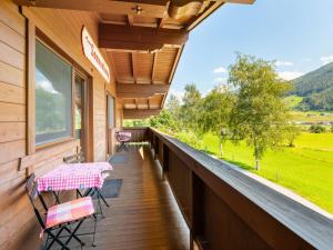 eine Veranda mit Stühlen, einem Tisch und einem Fenster in der Unterkunft Holiday Home Haus am Sonnenhang by Interhome in Spielbichl