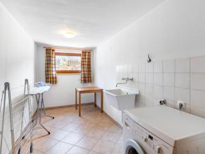 SpielbichlにあるHoliday Home Haus am Sonnenhang by Interhomeの洗濯機と窓のある洗濯室