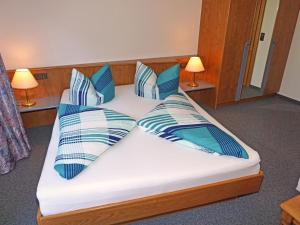 a bed with blue and white pillows on it at Apartment Erika by Interhome in Kappl