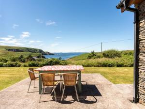 a table and chairs on a patio with a view of the ocean at Holiday Home Cuascrome by Interhome in Cahersiveen