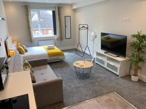 een woonkamer met een bed en een televisie bij Cosy Studio Flat - Near City Centre in Doncaster