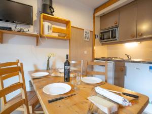 een keuken met een houten tafel en een fles wijn bij Apartment Arcelle-10 by Interhome in Val Thorens