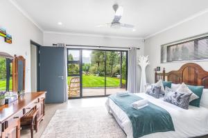a bedroom with a large bed with a desk and a sink at Rhino Retreat Clarens in Clarens