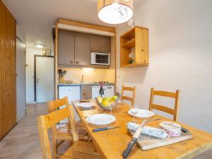 cocina con mesa de madera con sillas y comedor en Apartment Arcelle 614 by Interhome, en Val Thorens