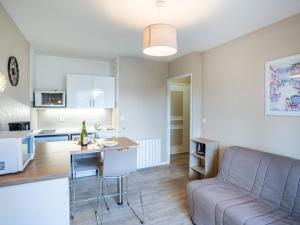 a living room and kitchen with a couch and a table at Apartment Fleur Marine-5 by Interhome in Cabourg