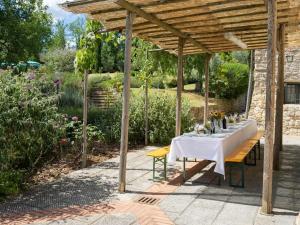 a table under a wooden pergola in a garden at Holiday Home La Badia by Interhome in Dicomano