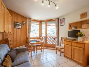 een woonkamer met een bank, een televisie en een tafel bij Apartment La Grande Chaume by Interhome in Les Deux Alpes