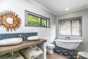 a bathroom with a tub and a sink and a toilet at Rhino Retreat Clarens in Clarens +46 photos